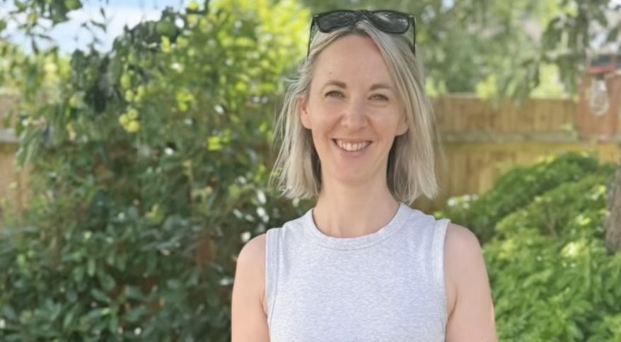 Tessa Gooding smiling calmly in her garden with a cup of tea. Tessa Spring: working with you to keep moving through life shifts